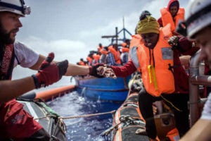 -FOTODELDIA- Alta mar, 21/04/2018.- Miembros de la ONG 'SOS Mediterranee' del buque 'Acuario' ayudan a una mujer durante una operación para rescatar a más de 250 inmigrantes en un barco de madera, a unos 50 kilómetros de la costa libia, en el Mar Mediterráneo, el 21 de abril de 2018. El Acuario la tripulación dirigió dos operaciones el 21 de abril y rescató a unas 350 personas, además de las 164 rescatadas la semana pasada y ya a bordo. (Libia) EFE / CHRISTOPHE PETIT TESSON: