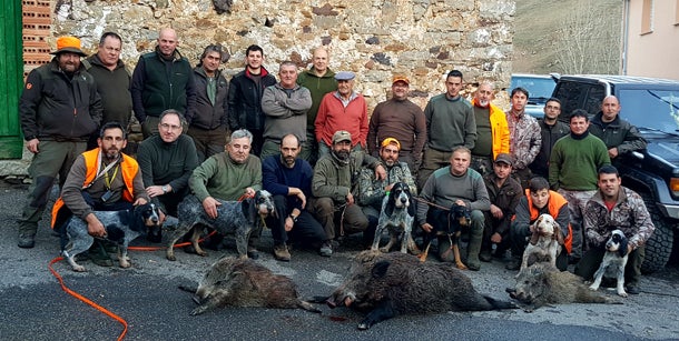 Grupo de cazadores asturianos, en Buiza, con tres jabalíes. :: D. M. M.