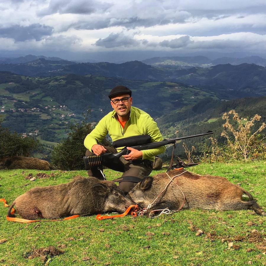 El parragués Aitor Collía, con dos berracos tumbados en el cuartel de Libardón, en la Reserva del Sueve. :: e. c.